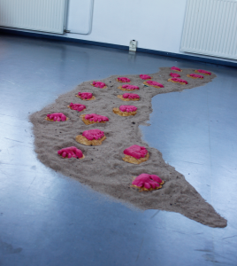 Painted plaster-cast toes on sand.