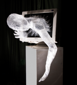 Plastic woman emerging from old computer screen.