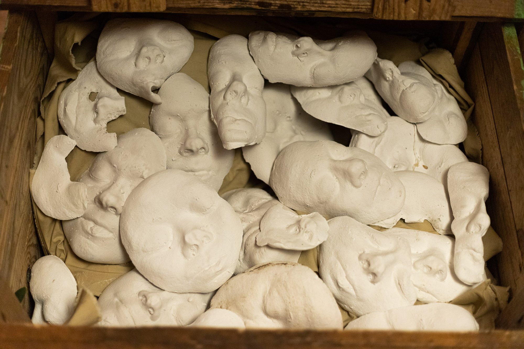 Chestful of distorted plaster faces.