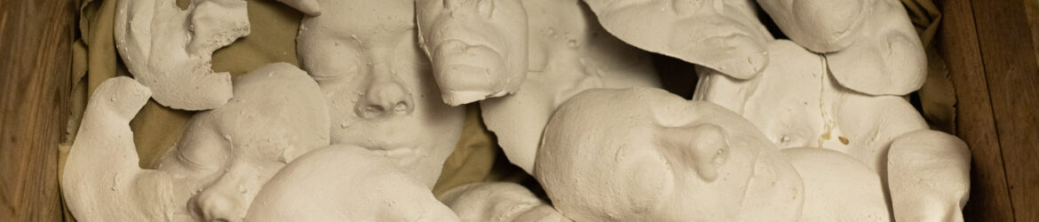 Chestful of distorted plaster faces.